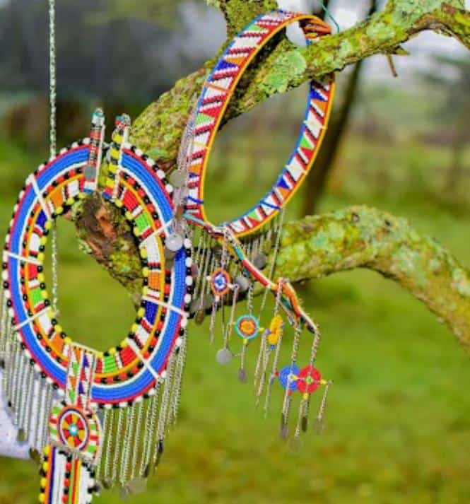 Colorful Maasai beaded jewelry hanging on a tree branch.
