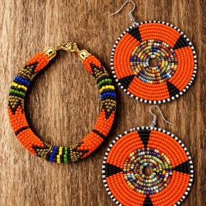 Handcrafted Maasai beaded drop earrings and Zulu design bracelet combo set by Nolari featuring vibrant colourful traditional African seed bead patterns, made in Kenya for Moransbead 📝 Product Description The Nolari Maasai Beaded Earrings & Zulu Bracelet Combo — Two Pieces. One Story. Why choose one when you can have both? This handcrafted jewellery combo by Nolari, a skilled Maasai women artisan working with Moransbead in Kenya, pairs vibrant beaded drop earrings with a bold Zulu-inspired bracelet — two culturally rich pieces designed to be worn together and treasured forever. Each piece is individually hand-beaded by Nolari in vibrant traditional African seed bead patterns, coordinated to complement each other perfectly while celebrating two of Africa's most iconic beadwork traditions — Maasai and Zulu — in one stunning set. What's Included: ✦ 🌟 1 pair of Maasai beaded drop earrings — lightweight and elegant ✦ 🌟 1 Zulu design beaded bracelet — bold and culturally rich ✦ 🎁 Beautifully packaged and ready to gift or wear Key Features: ✦ Two piece coordinated African jewellery set ✦ Hand-beaded by Nolari in traditional Maasai & Zulu patterns ✦ Vibrant seed beads — multiple colour combinations available ✦ Lightweight earrings — comfortable for all-day wear ✦ Bracelet fits most wrist sizes comfortably ✦ Every set is unique — no two combos are ever the same ✦ Ethically handmade in Kenya by Nolari for Moransbead Style It With: 🌟 Nolari Maasai Beaded Fedora Hat 🌟 Kisieku Maasai Beaded Leather Sandals for Women 🌟 Naiswaku Large Beaded Leather & Sisal Handbag Arrives beautifully packaged — the perfect gift for any occasion. Minor bead variations are Nolari's handmade signature — not imperfections. 📦 Ships worldwide via DHL | 🌍 Handmade in Kenya by Nolari for Moransbead | 💛 Every combo is one of a kind 🔍 Secondary Keywords maasai beaded earrings bracelet set, african jewellery combo kenya, zulu bracelet maasai earrings set, nolari moransbead jewellery, kenyan beaded jewellery combo, african beaded jewellery set kenya, unique handmade jewellery combo kenya Would you like to move on to the next product?
