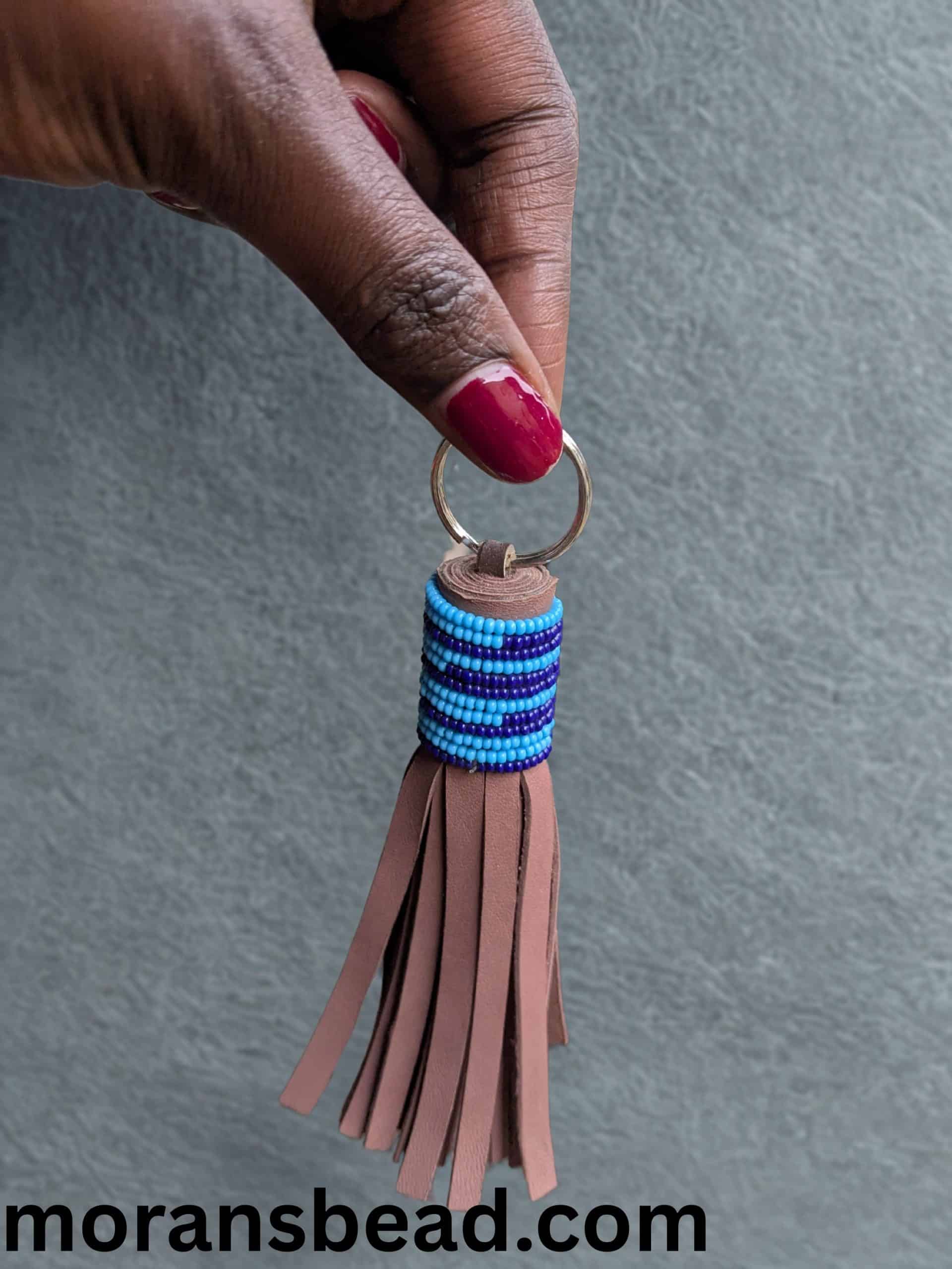Handcrafted Maasai beaded leather keychain with colorful traditional patterns and leather tassels.