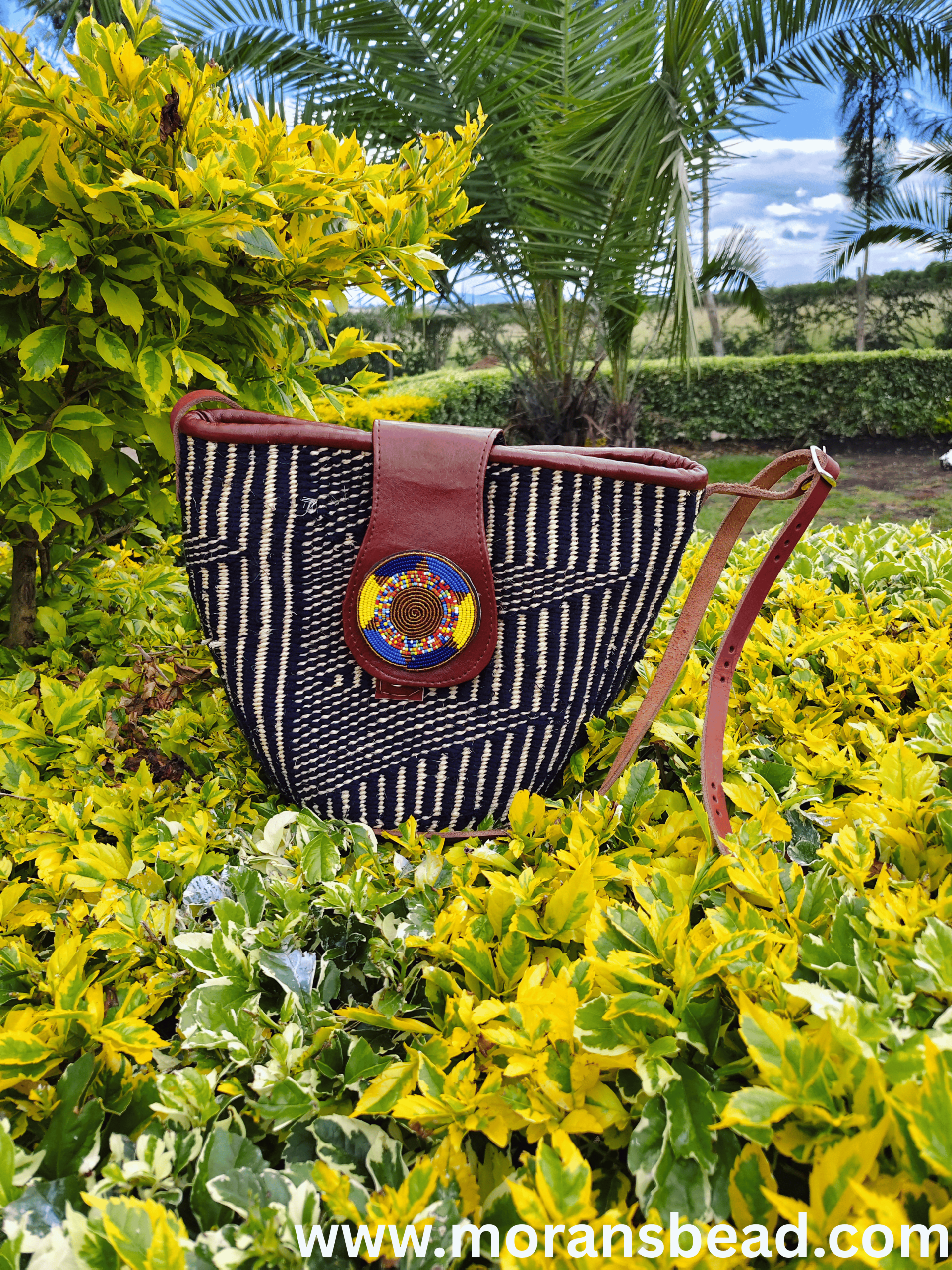 Spacious handcrafted Maasai beaded leather and sisal handbag by Naiswaku, featuring woven sisal body, genuine leather handles and trim, and colourful hand-beaded Maasai detail, made in Kenya for Moransbead